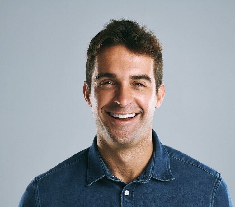 Smiling young man in denim shirt after receiving New Patient Offers at Craft Dental